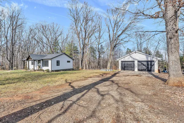 a front view of a house with a yard covered with snow