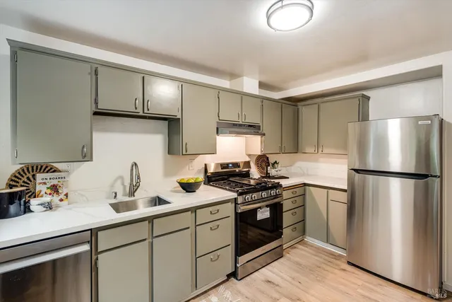 a kitchen with a sink stainless steel appliances and cabinets