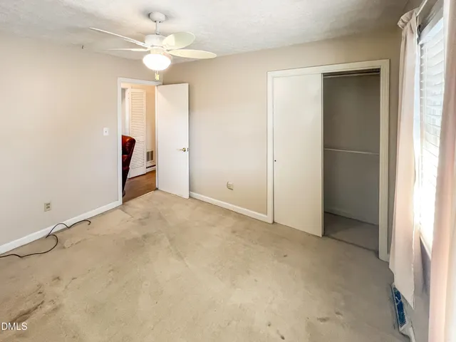 an empty room with fan and windows