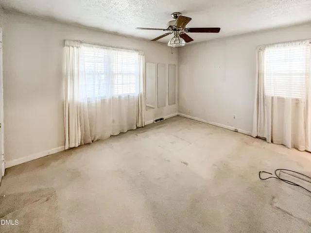 a view of a hallway with wooden floor and a door