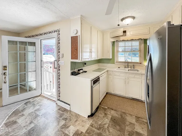 a kitchen with refrigerator and cabinets
