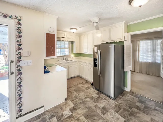 a view of a kitchen with refrigerator and a stove
