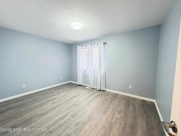 a view of empty room with wooden floor