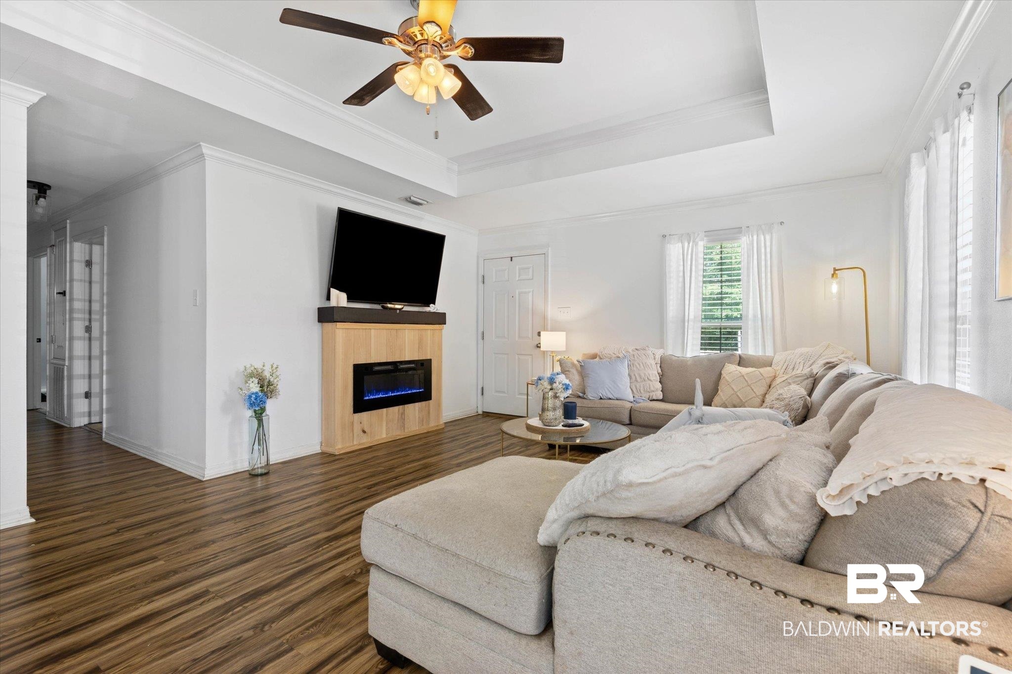1411 Creola Axis Loop Road North Axis, AL 36505 - Photo 3 of 21 Living area with dark wood-style floors, a glass covered fireplace, ceiling fan, baseboards, and ornamental molding