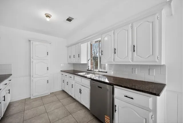 a kitchen with white cabinets and a sink