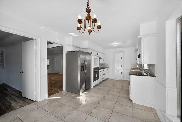 a kitchen with stainless steel appliances granite countertop a refrigerator and a stove top oven
