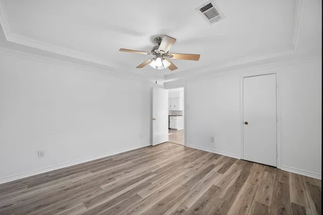 a view of a room with wooden floor and a ceiling fan
