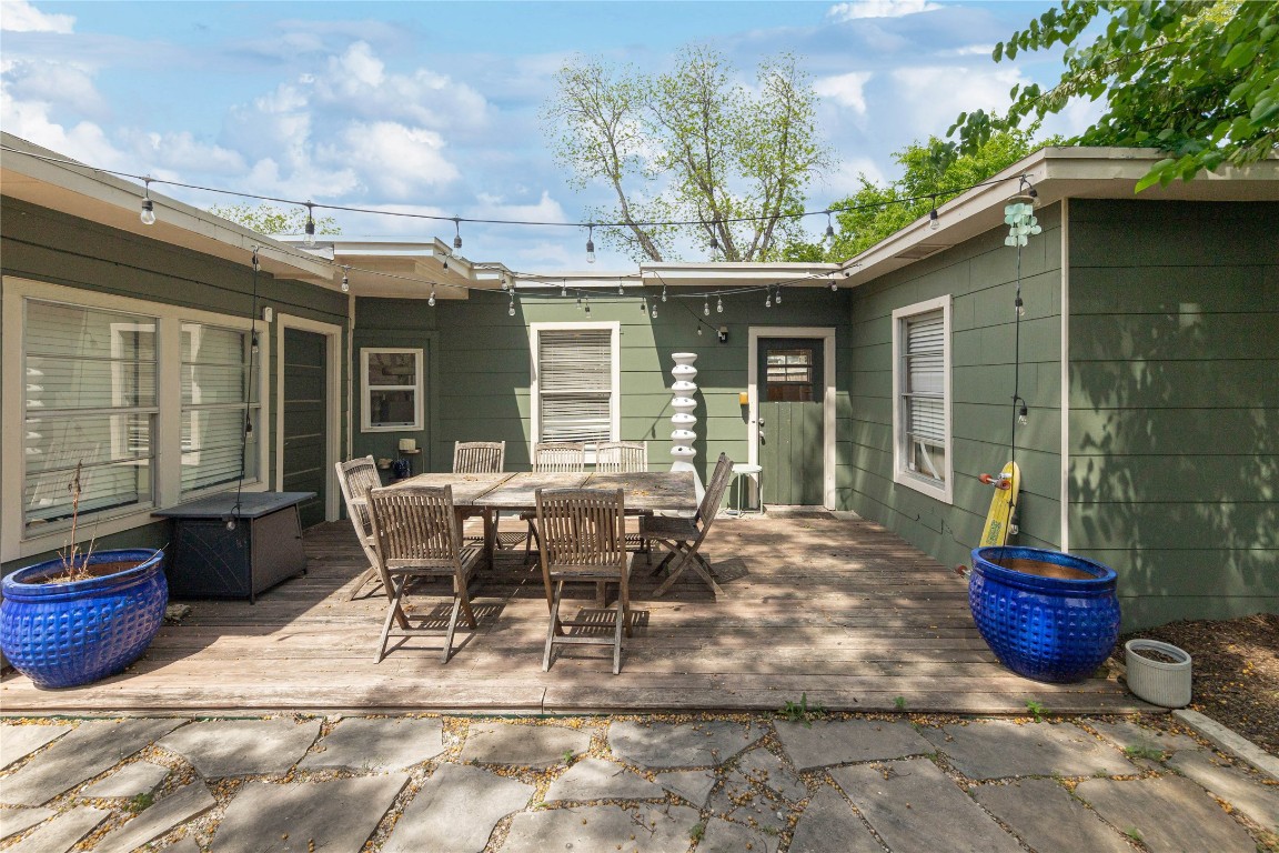 a view of a patio with table and chairs potted plants and a large tree