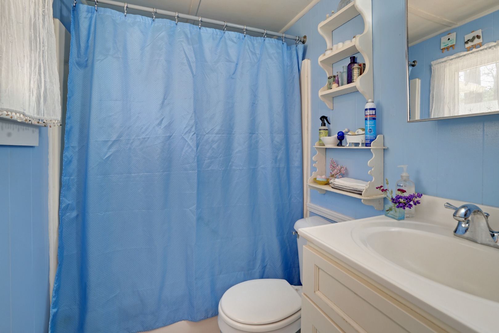 21 Clay Pit Road Edgartown, MA 02539 - Photo 16 of 20 a bathroom with a sink a toilet and shower curtain