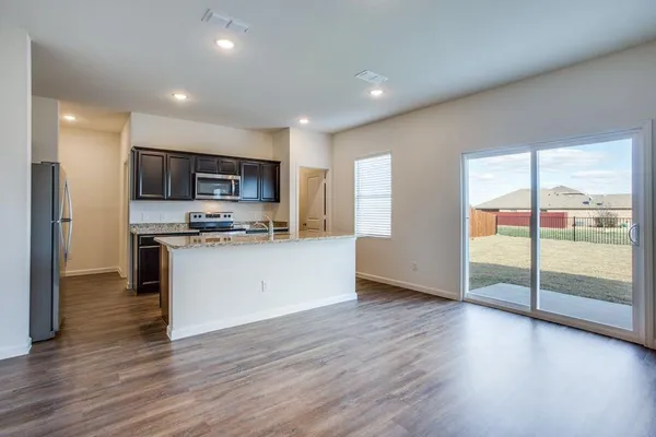 a kitchen with stainless steel appliances granite countertop a stove top oven a sink and a microwave