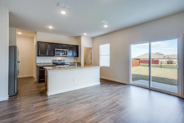 a kitchen with stainless steel appliances granite countertop a stove top oven a sink and a microwave