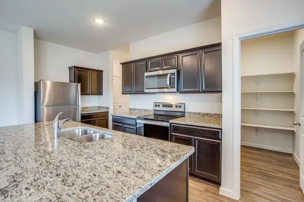 a kitchen with sink cabinets and wooden floor