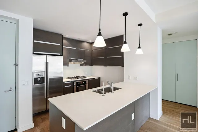 a kitchen with kitchen island a counter top space stainless steel appliances and cabinets