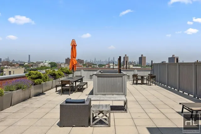a view of a terrace with furniture and city view