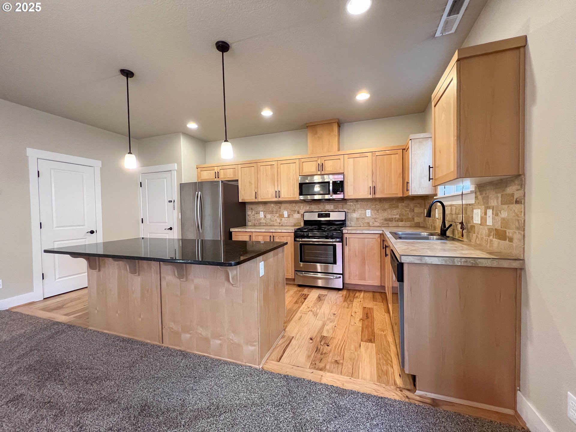 386 Southwest 203rd Terrace Beaverton, OR 97006 - Photo 4 of 24 a kitchen with stainless steel appliances granite countertop a sink refrigerator and microwave