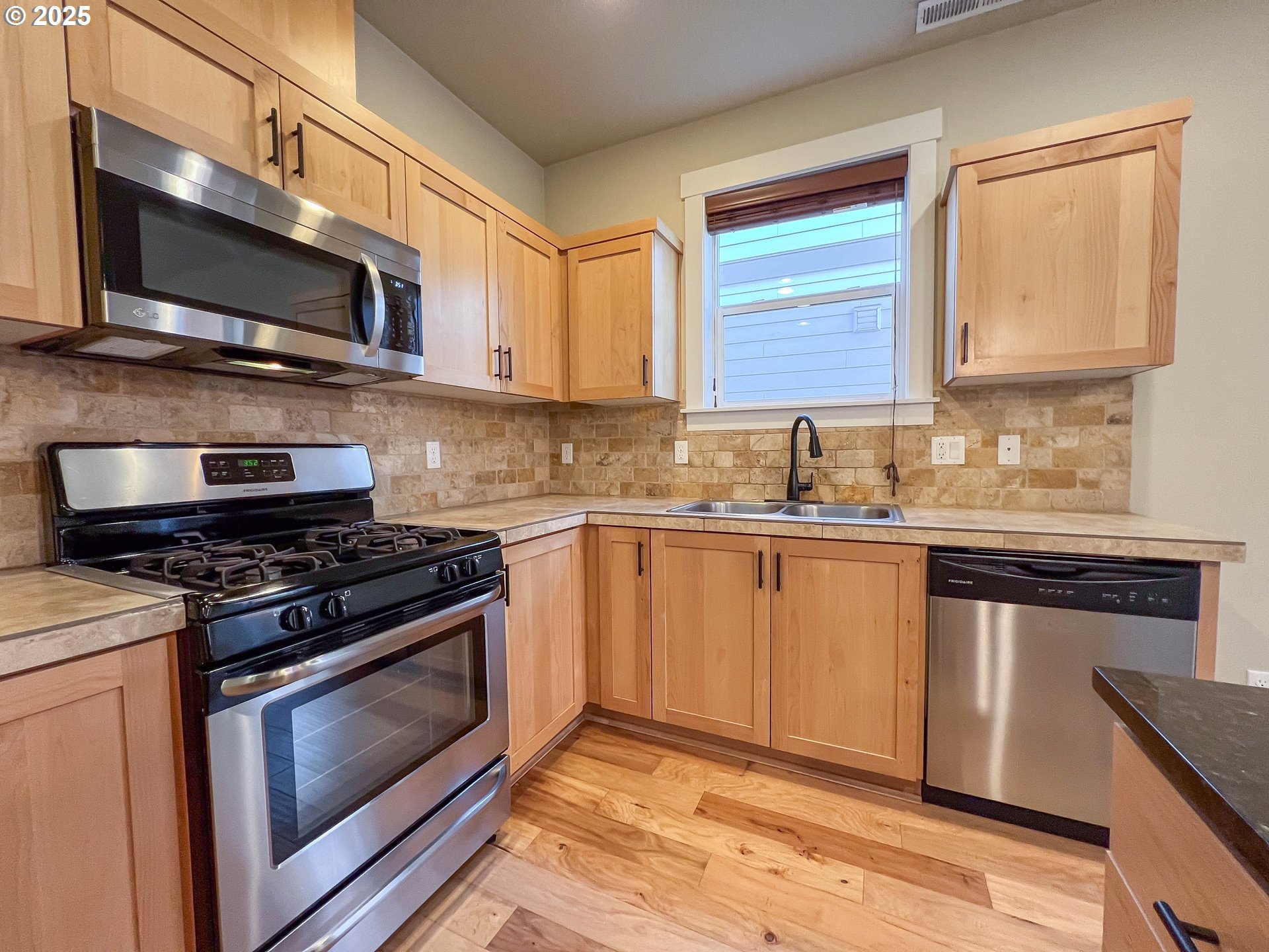 386 Southwest 203rd Terrace Beaverton, OR 97006 - Photo 5 of 24 a kitchen with stainless steel appliances a sink a stove a microwave and cabinets