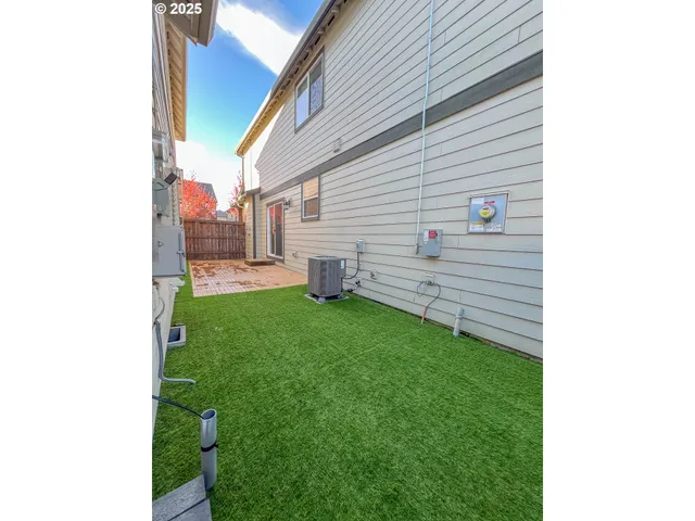 a view of a backyard with couches plants and large tree