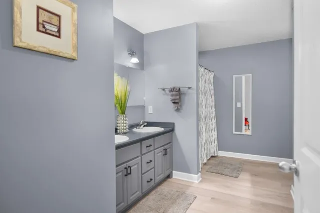 a spacious bathroom with a granite countertop sink and a mirror