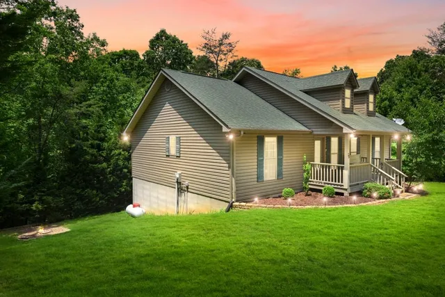 a front view of a house with a yard and green space