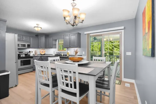 a view of a dining room with furniture a chandelier and wooden floor