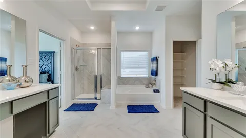a en suite bathroom with a double vanity sink and a mirror