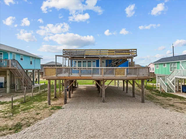 a view of a house with a wooden deck and furniture