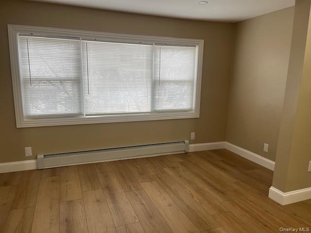 85-40 111th Street, Unit 2 Queens, NY 11418 - Photo 3 of 21 an empty room with wooden floor and windows
