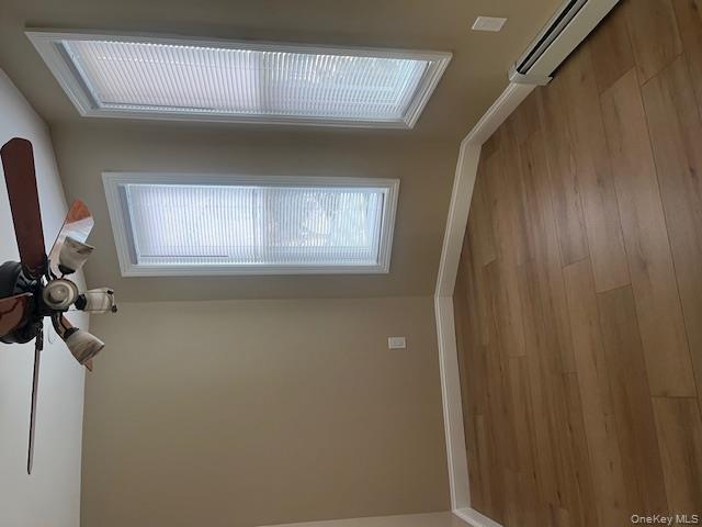 85-40 111th Street, Unit 2 Queens, NY 11418 - Photo 4 of 21 an empty room with wooden floor fan and windows