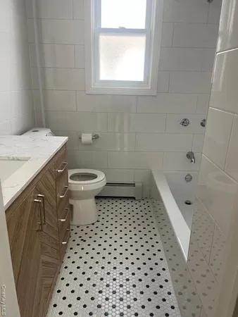 a bathroom with a sink a toilet a window and a shower