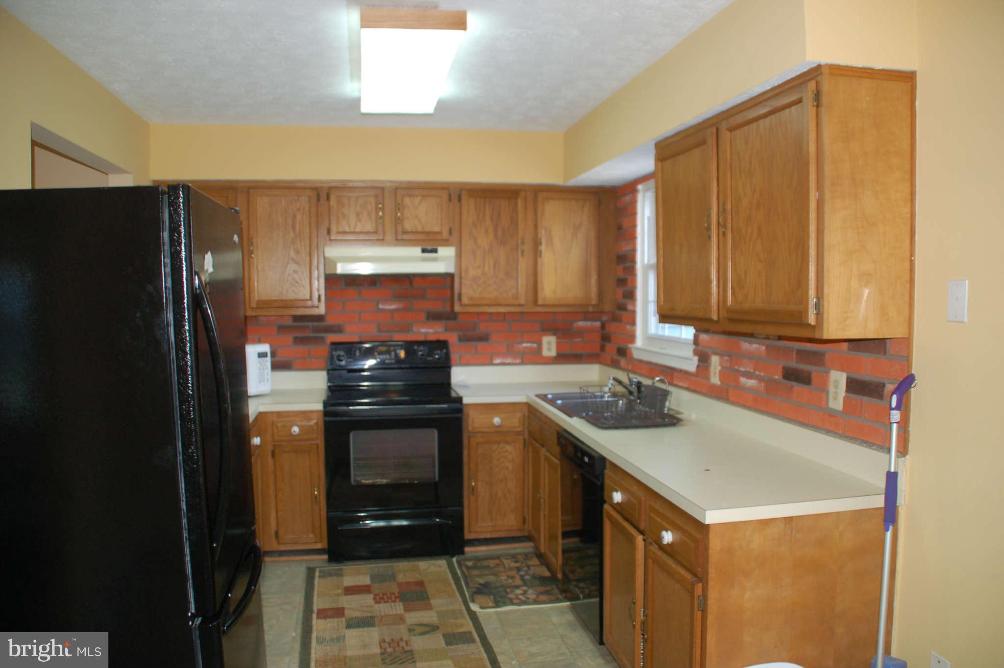 13982 New Braddock Road Centreville, VA 20121 - Photo 5 of 16 a kitchen with a sink stove and refrigerator