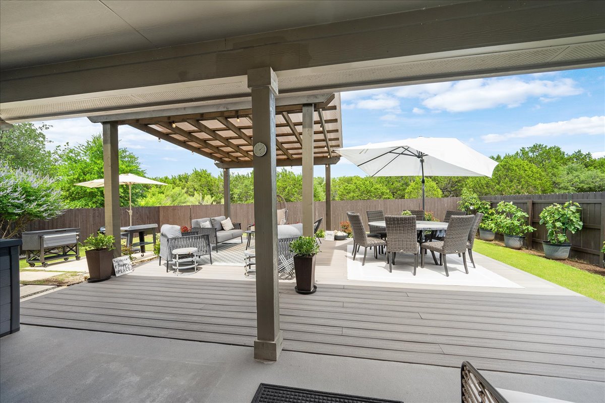 3000 Rio Verde Drive Leander, TX 78641 - Photo 18 of 23 a view of a patio with a dining table and chairs under an umbrella with a small yard