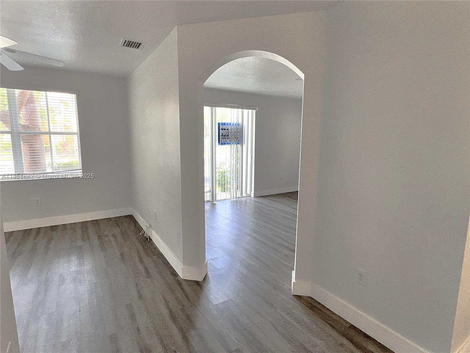 2933 Southeast 2nd Drive, Unit 2 Homestead, FL 33033 - Photo 13 of 38 an empty room with wooden floor and windows