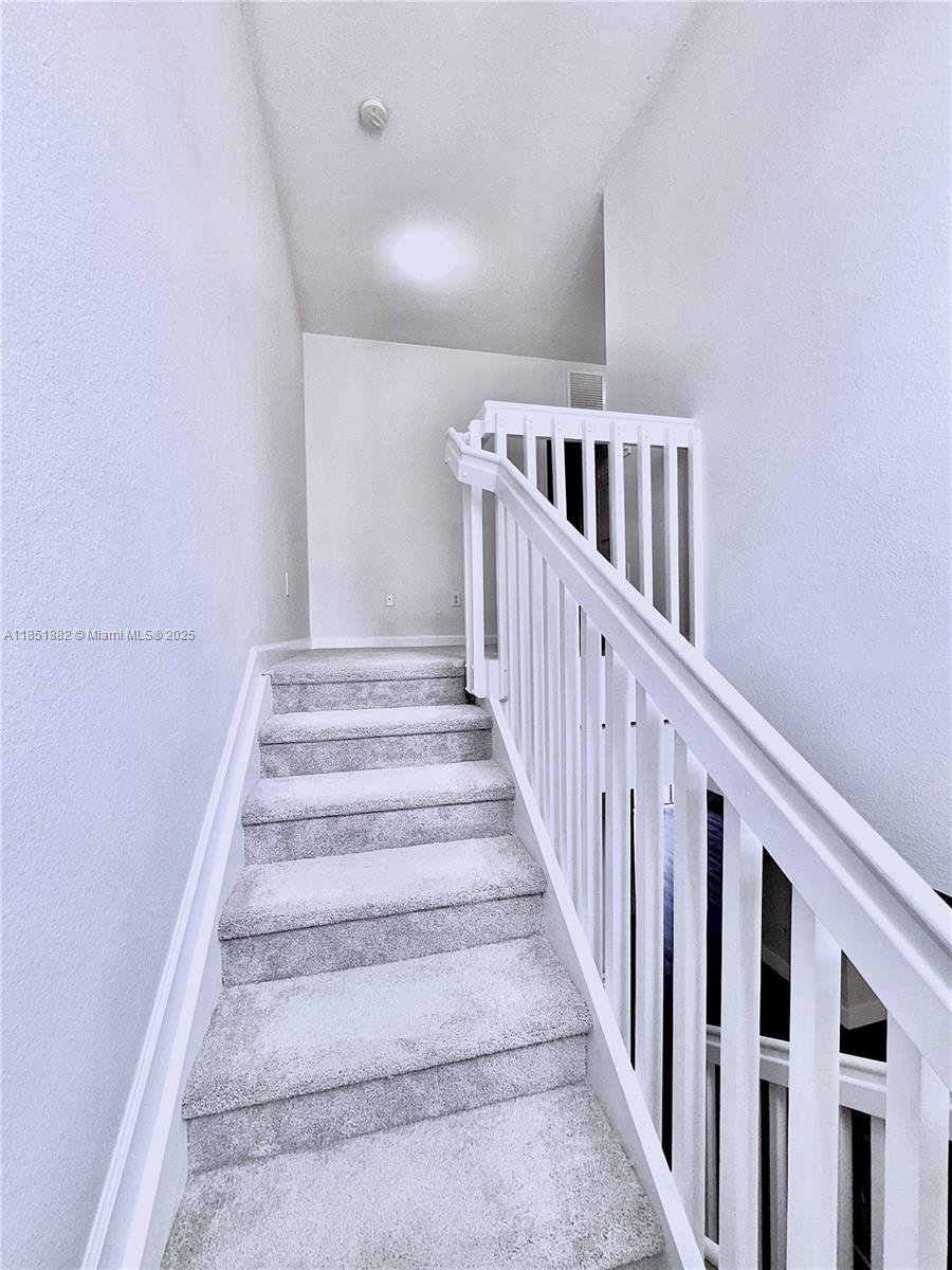 2933 Southeast 2nd Drive, Unit 2 Homestead, FL 33033 - Photo 25 of 38 a view of staircase with lots of frames on wall