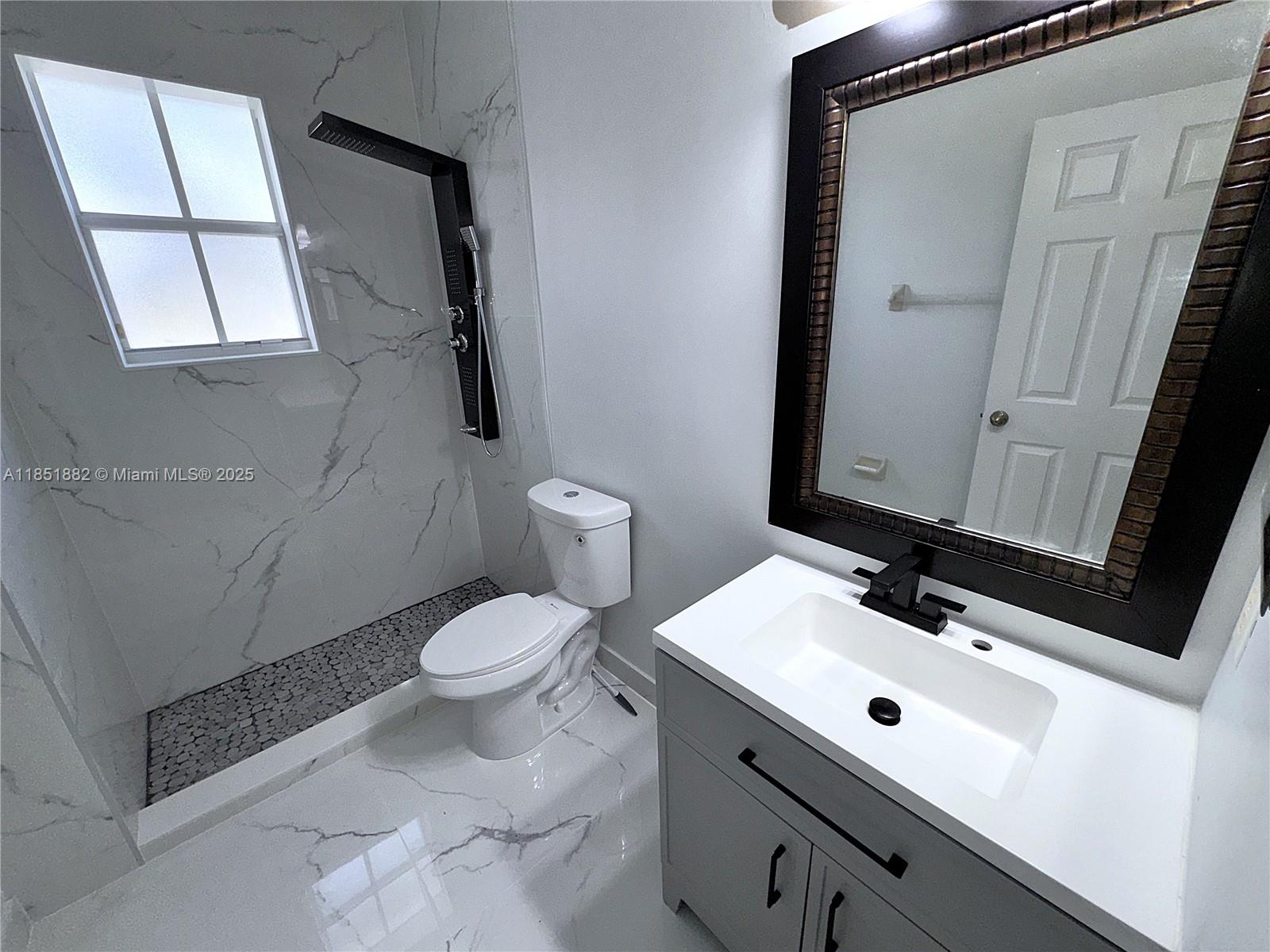 2933 Southeast 2nd Drive, Unit 2 Homestead, FL 33033 - Photo 31 of 38 a bathroom with a sink toilet and mirror