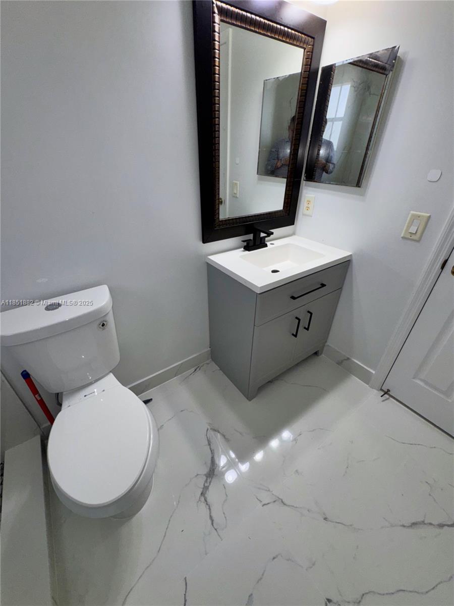 2933 Southeast 2nd Drive, Unit 2 Homestead, FL 33033 - Photo 33 of 38 a bathroom with a toilet sink and mirror