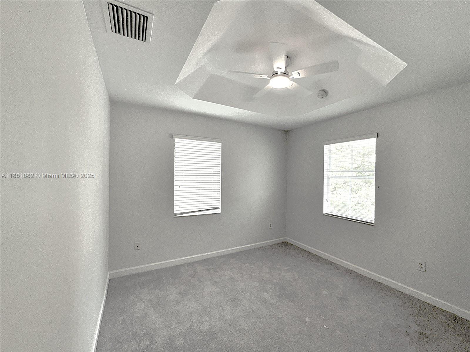 2933 Southeast 2nd Drive, Unit 2 Homestead, FL 33033 - Photo 34 of 38 an empty room with windows and chandelier fan