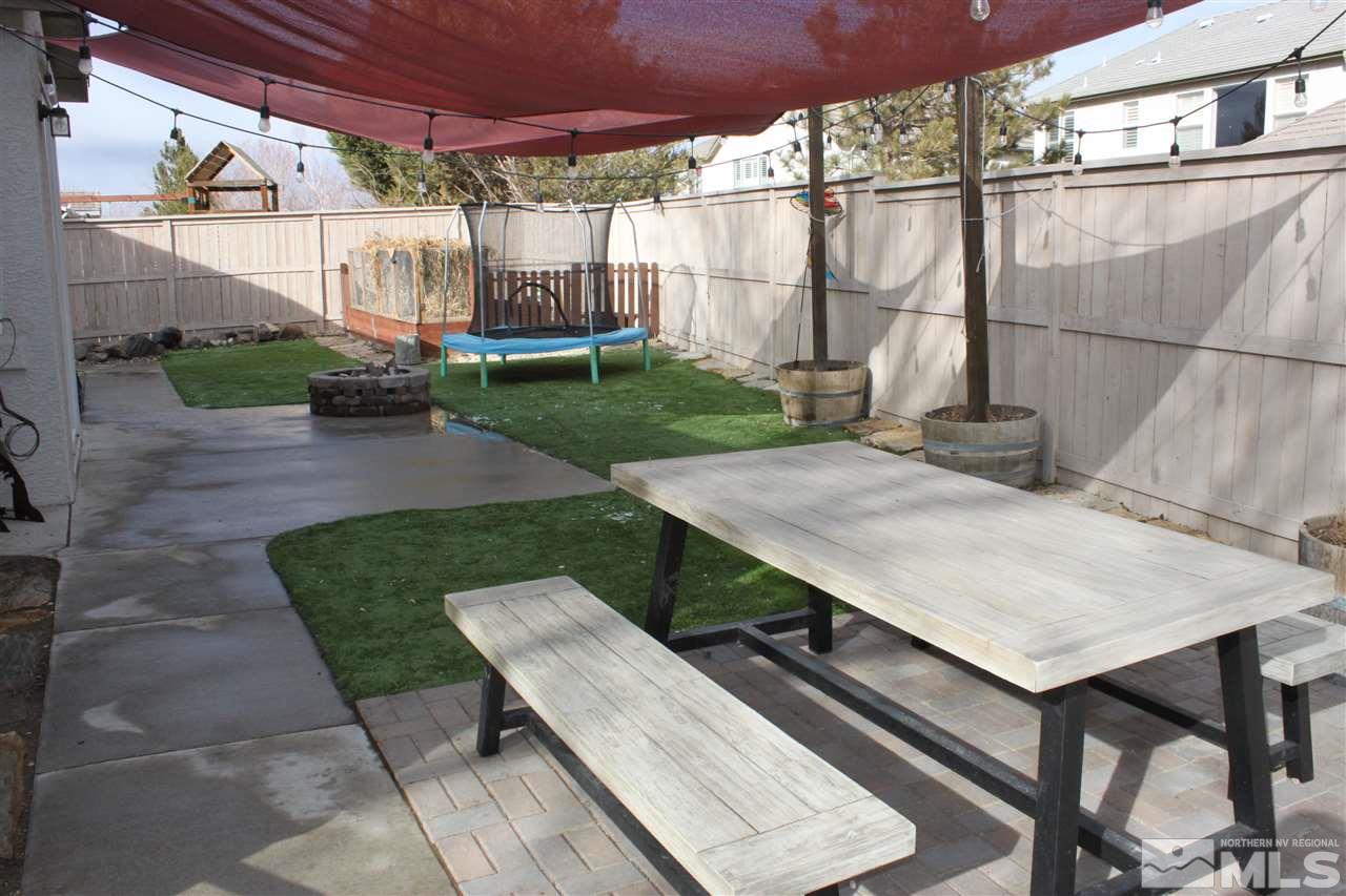 2495 Spring Flower Drive Reno, NV 89521 - Photo 24 of 30 a view of a patio with table and chairs with wooden floor and fence