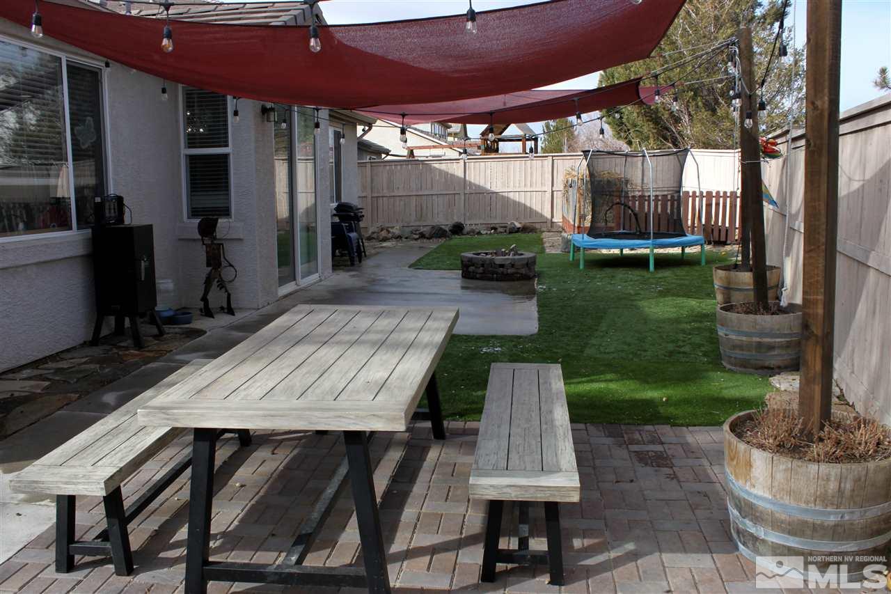 2495 Spring Flower Drive Reno, NV 89521 - Photo 25 of 30 a view of a patio with table and chairs potted plants and large tree
