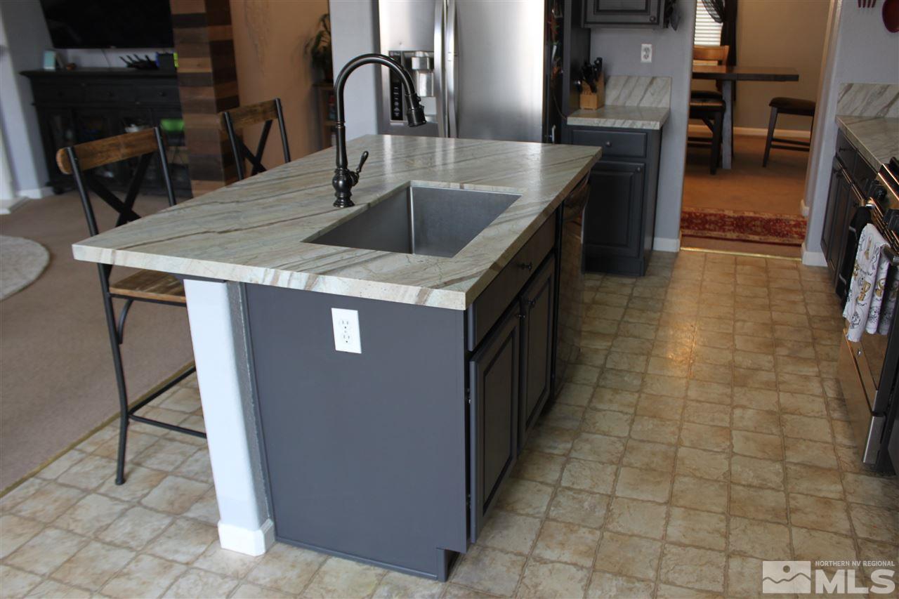 2495 Spring Flower Drive Reno, NV 89521 - Photo 7 of 30 a kitchen with stainless steel appliances granite countertop a sink and a counter top space
