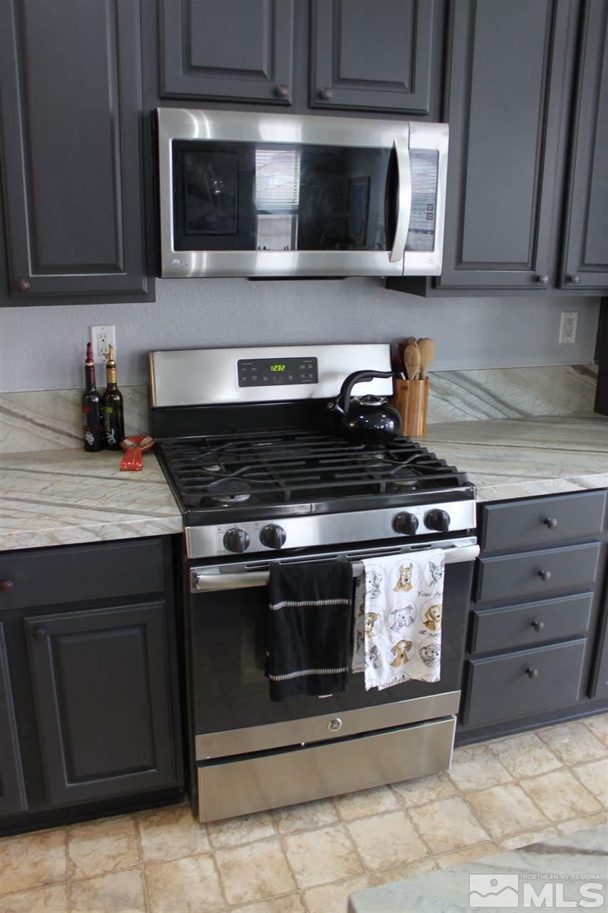 2495 Spring Flower Drive Reno, NV 89521 - Photo 8 of 30 a kitchen with stainless steel appliances granite countertop a stove and a microwave