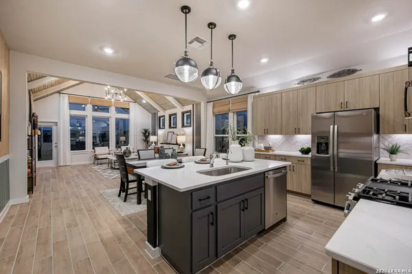 a large kitchen with a counter space a sink appliances and living room view