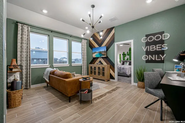a living room with furniture a flat screen tv and a floor to ceiling window