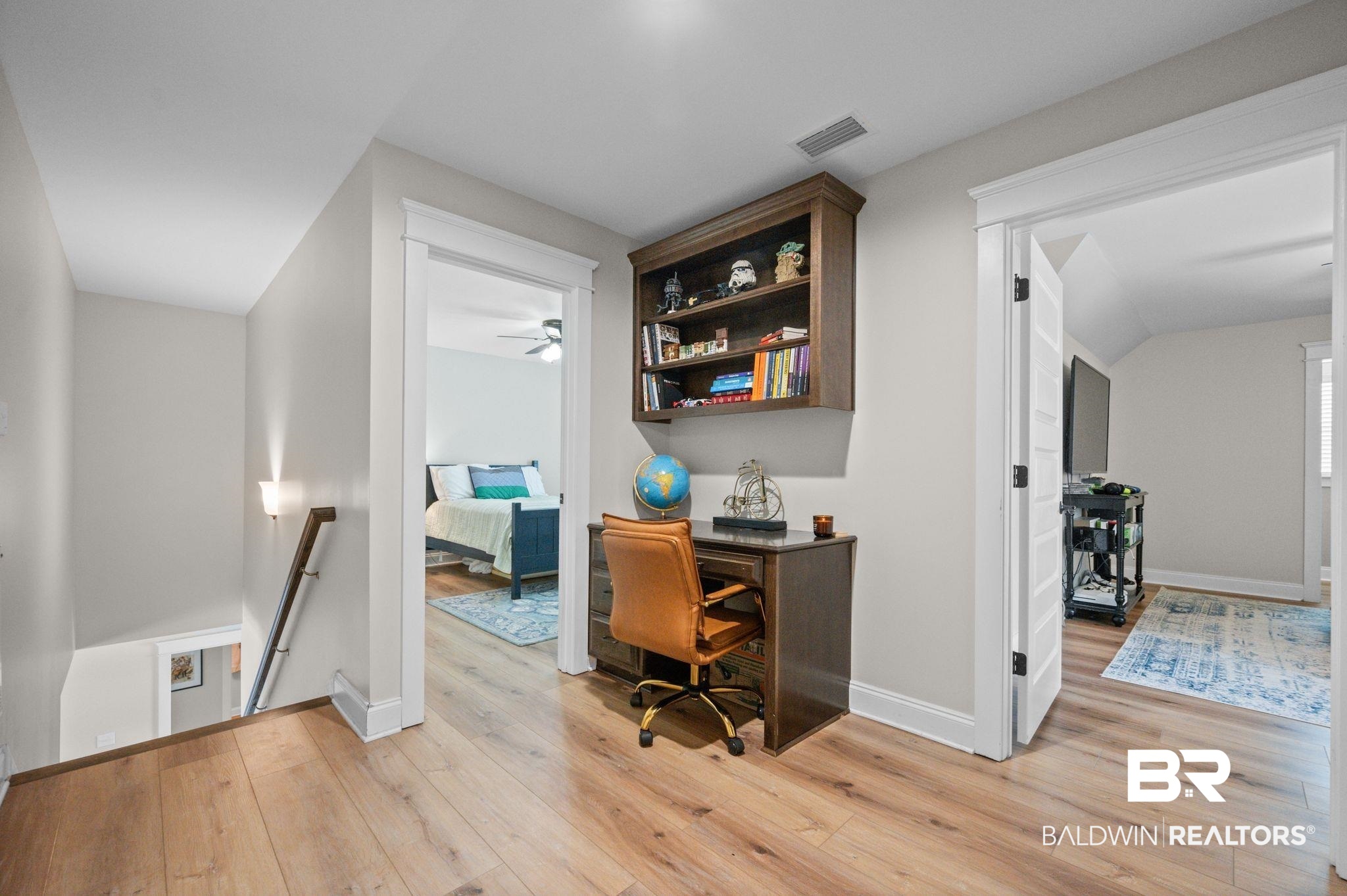 409 Fortune Drive Fairhope, AL 36532 - Photo 25 of 42 Upper-level hallway featuring wood-finish flooring, a built-in wood desk with an integrated bookshelf, white trim, and light gray wall finishes