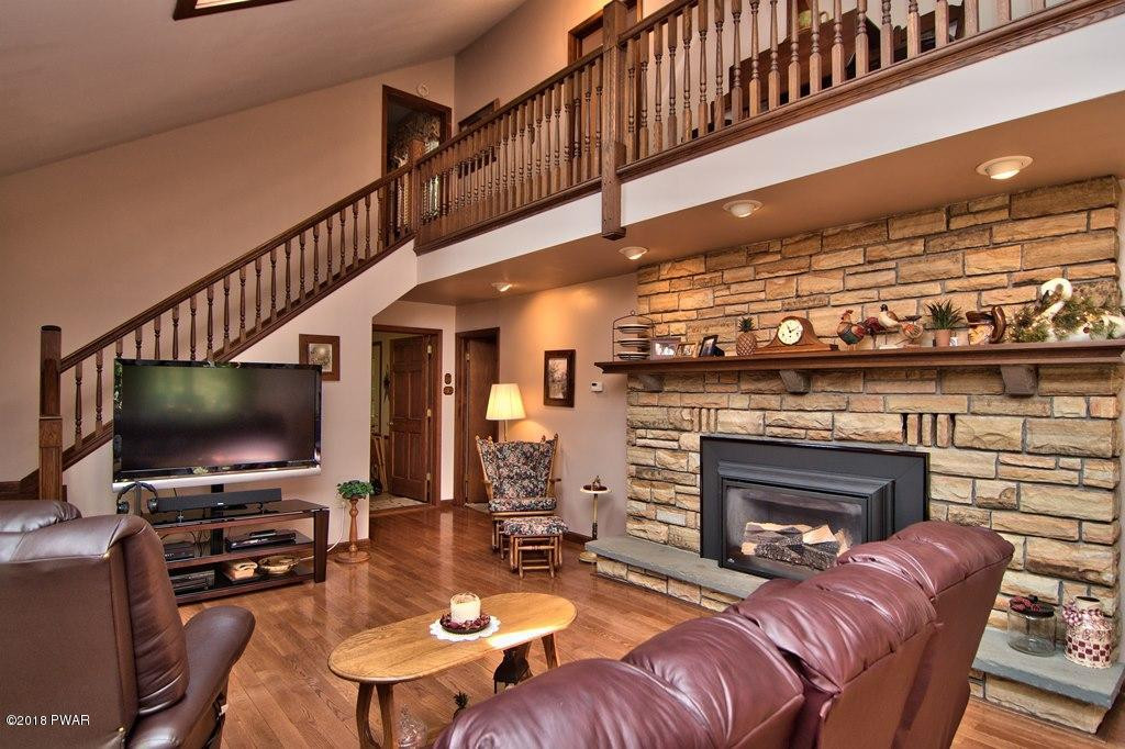 1 East Lake Road Moscow, PA 18444 - Photo 7 of 88 a living room with furniture a flat screen tv and a fireplace