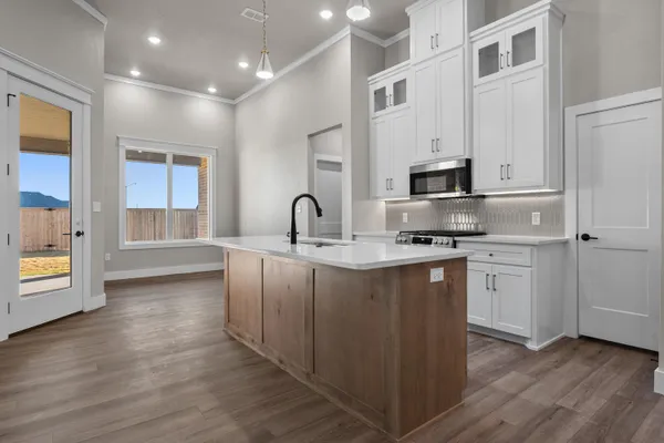 a kitchen with granite countertop a stove and a wooden floors