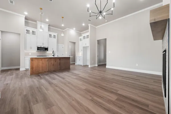 a large kitchen with cabinets wooden floor and a sink