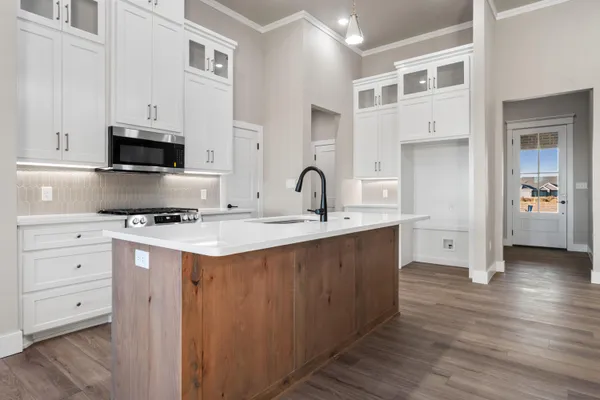 a large kitchen with stainless steel appliances a large counter top a sink and a refrigerator