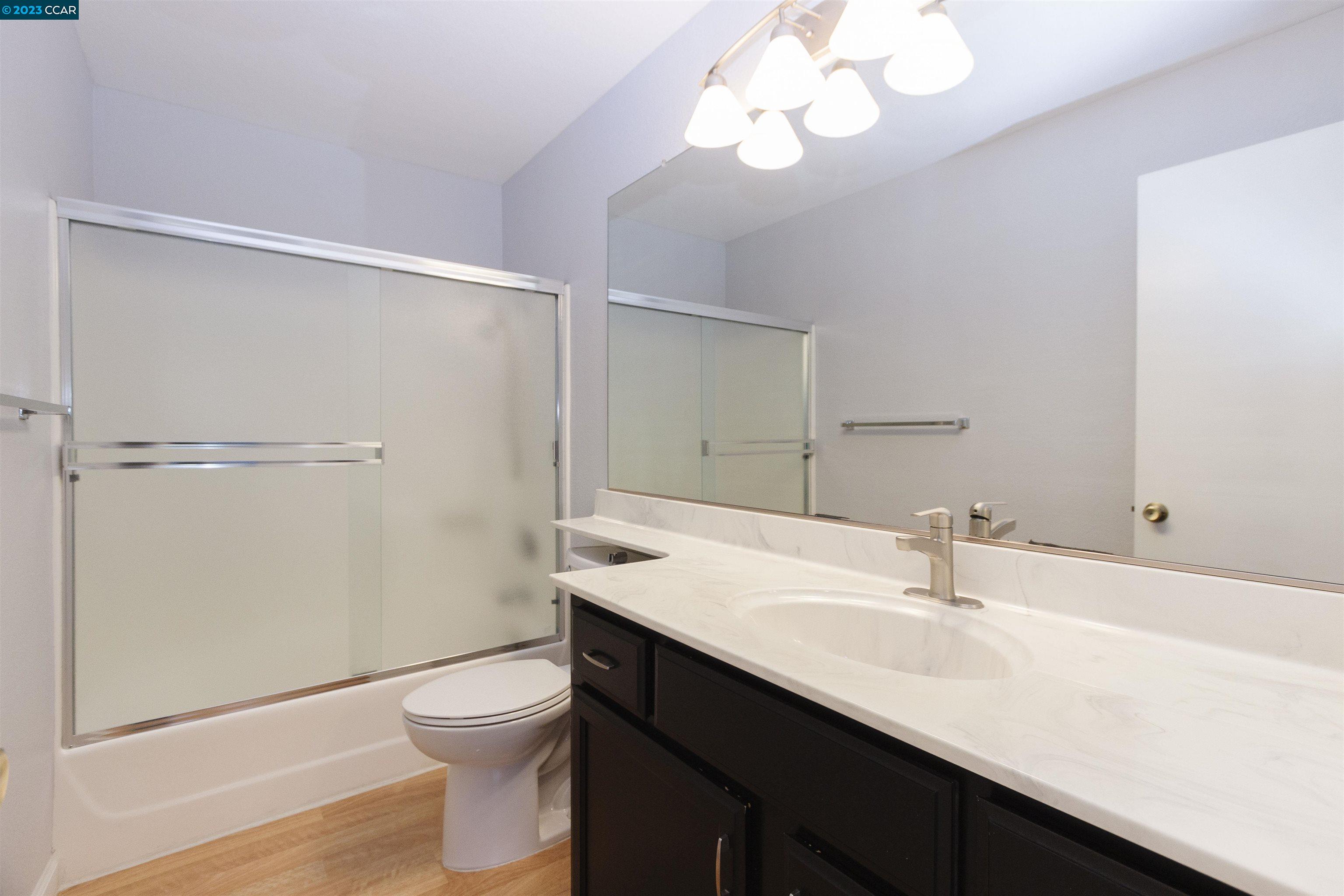 5291 Pebble Glen Drive Concord, CA 94521 - Photo 14 of 21 a bathroom with a sink a toilet a light fixture and a mirror