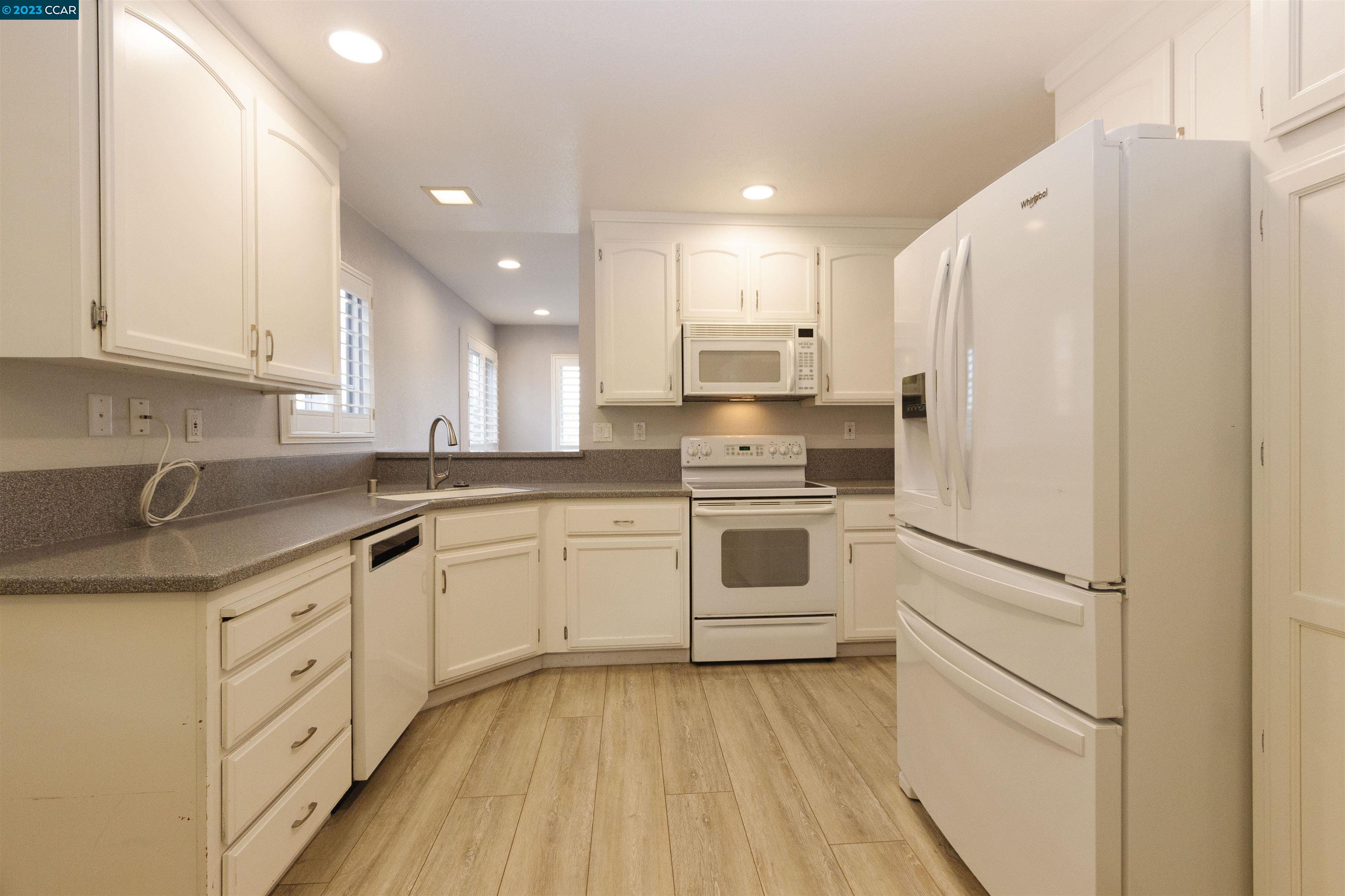5291 Pebble Glen Drive Concord, CA 94521 - Photo 2 of 21 a kitchen with white cabinets and white appliances