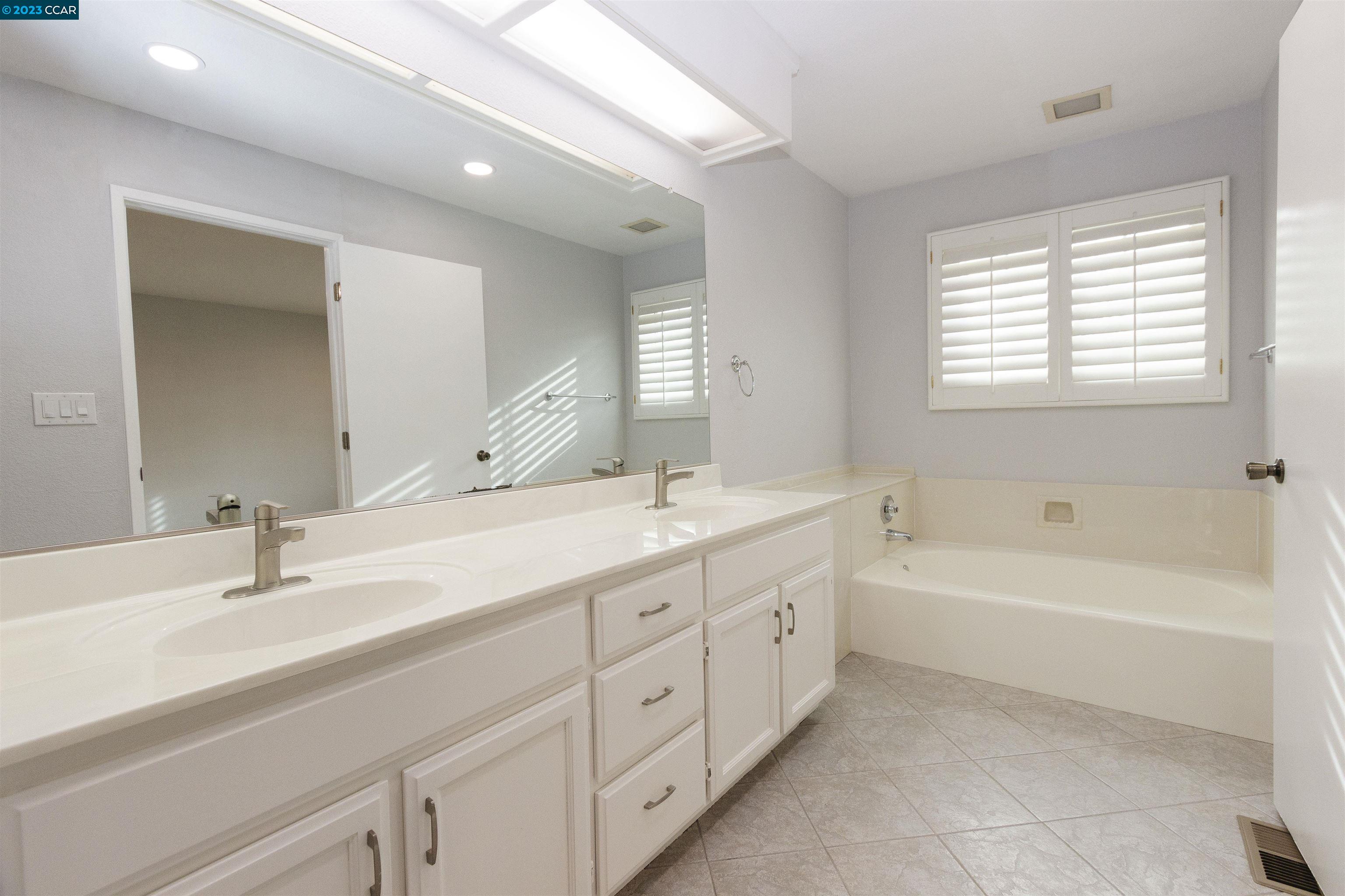 5291 Pebble Glen Drive Concord, CA 94521 - Photo 10 of 21 a bathroom with a double vanity sink and a bathtub